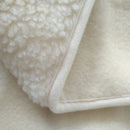 Gros plan sur la face douce et le bord de la couverture chauffante Zen Massage